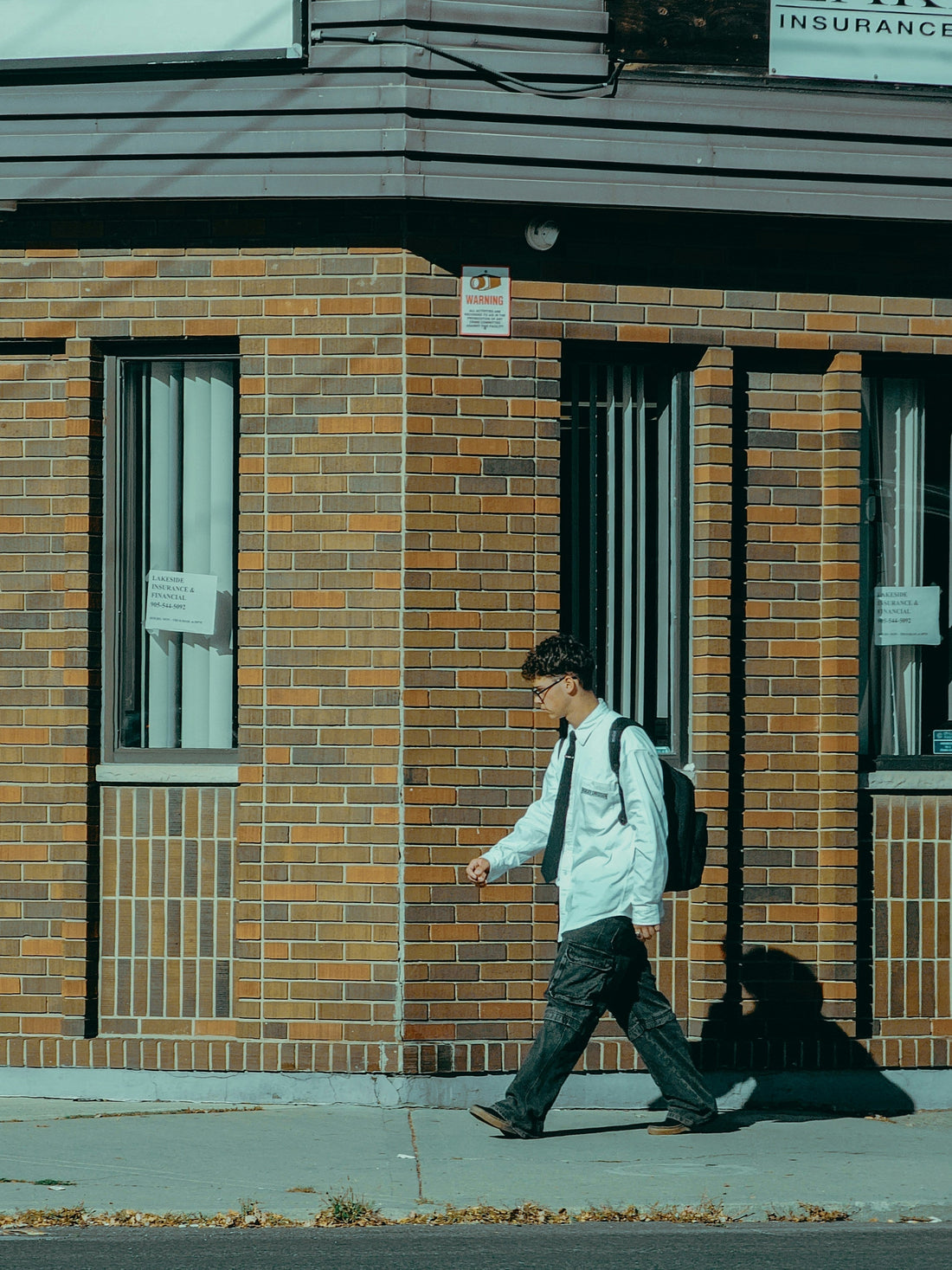 Foto de Lavish Malar en Unsplash. Joven con mochila anda por la calle.